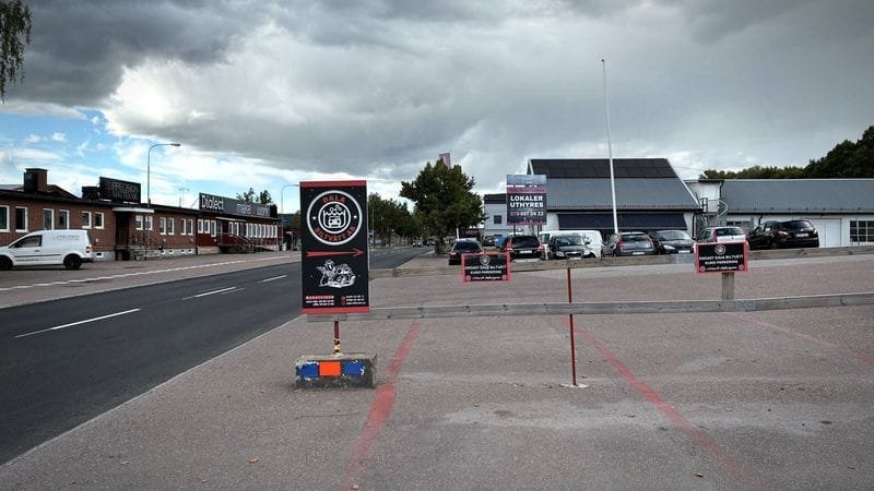 Infarten till Dala Biltvätt från gatan, med skyltar vid infarten och lokalen i bakgrunden.