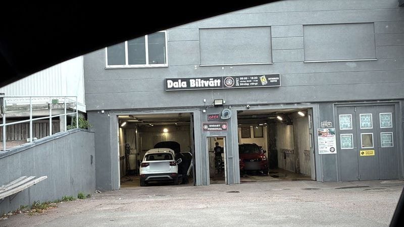 Dala Biltvätts lokal sedd inifrån en bil vid infarten, med portarna till tvätthallen rakt fram.